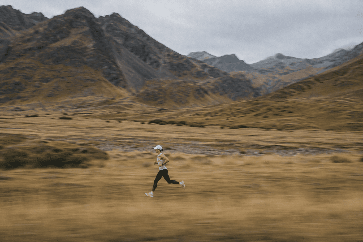 Runner crossing a mountain landscape